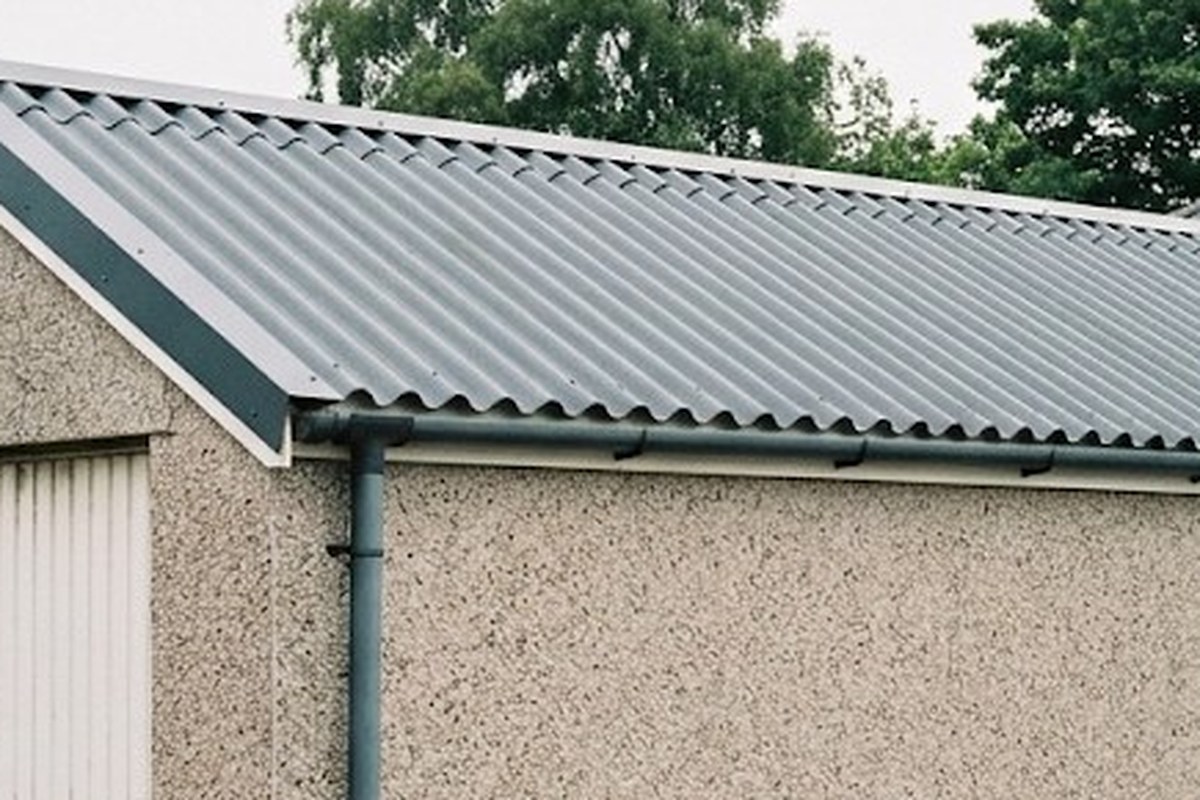 Illustration of solar panels on a garage roof feeding a house and a battery